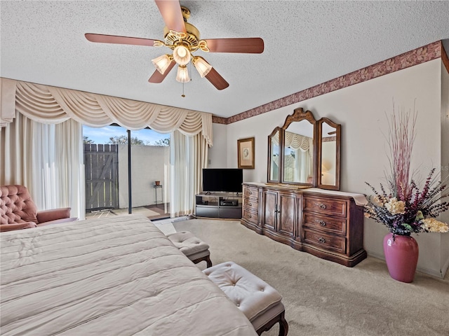 bedroom with a textured ceiling, access to outside, carpet, and a ceiling fan