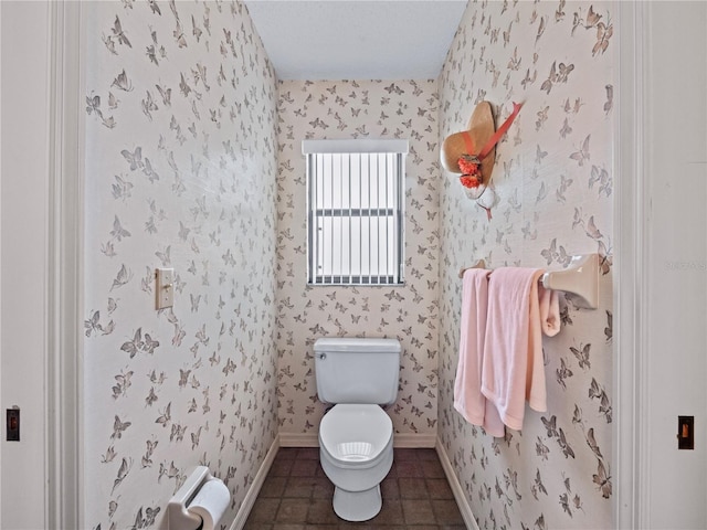 bathroom featuring baseboards, tile patterned floors, toilet, and wallpapered walls