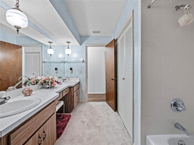 full bath featuring double vanity, visible vents, tub / shower combination, a sink, and a textured ceiling