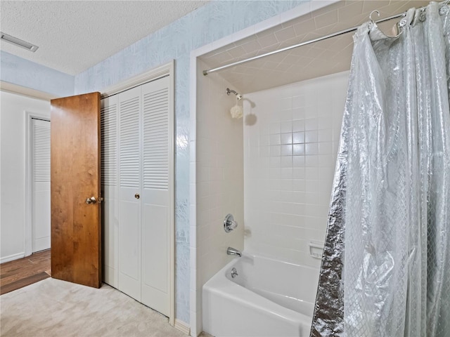 bathroom with a closet, visible vents, shower / tub combo, a textured ceiling, and wallpapered walls