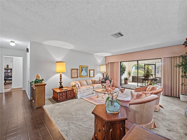 living area featuring a textured ceiling, visible vents, and baseboards