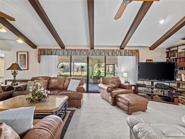 living area with beam ceiling, a ceiling fan, a textured ceiling, and carpet flooring