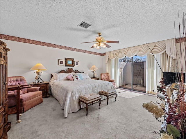 carpeted bedroom with access to exterior, a ceiling fan, visible vents, and a textured ceiling