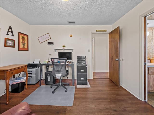 office featuring visible vents, a textured ceiling, and wood finished floors