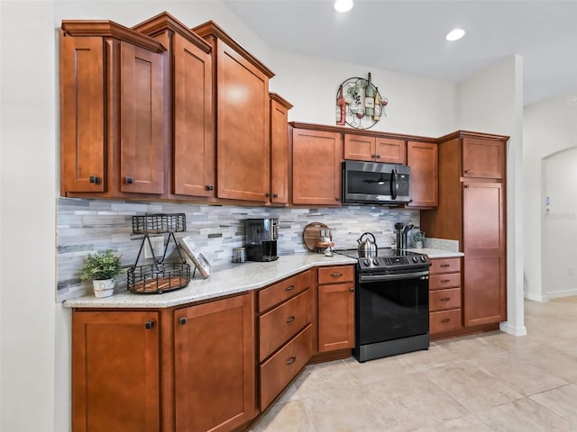 kitchen featuring stainless steel microwave, light stone countertops, black / electric stove, backsplash, and recessed lighting