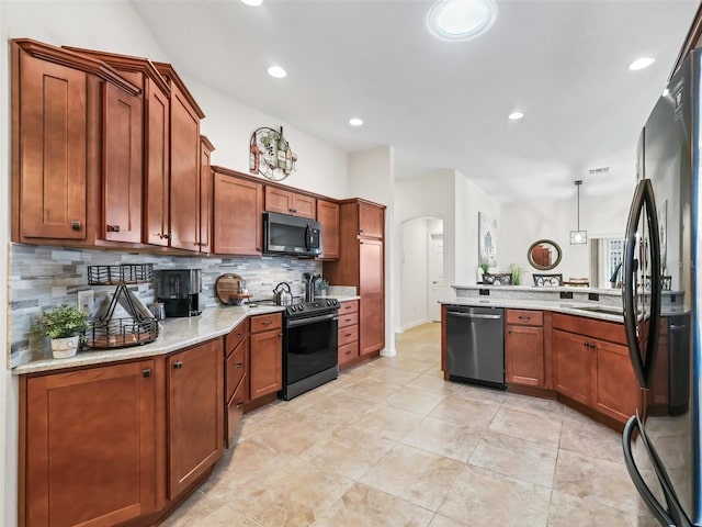 kitchen featuring arched walkways, black appliances, brown cabinets, and decorative backsplash