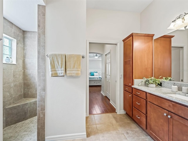 ensuite bathroom featuring ensuite bathroom, vanity, walk in shower, baseboards, and tile patterned floors