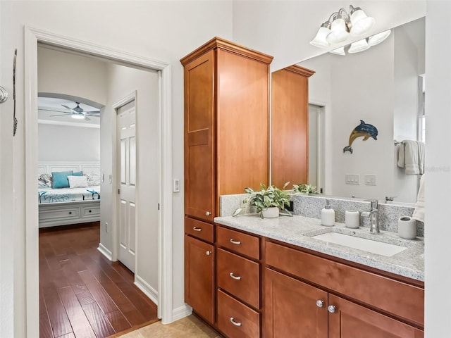 bathroom with ensuite bathroom, ceiling fan, wood finished floors, and vanity