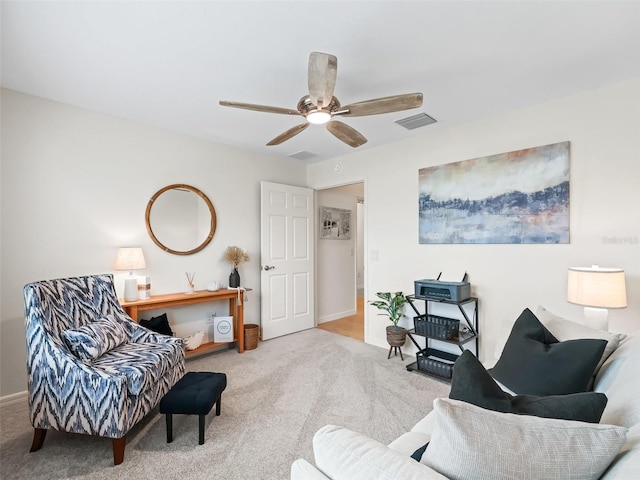 sitting room with carpet, visible vents, and ceiling fan