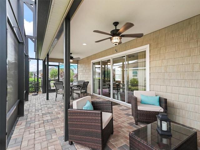 view of patio / terrace with glass enclosure, an outdoor hangout area, a ceiling fan, and outdoor dining space