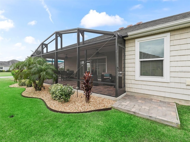 rear view of property with a lanai, a yard, and a patio