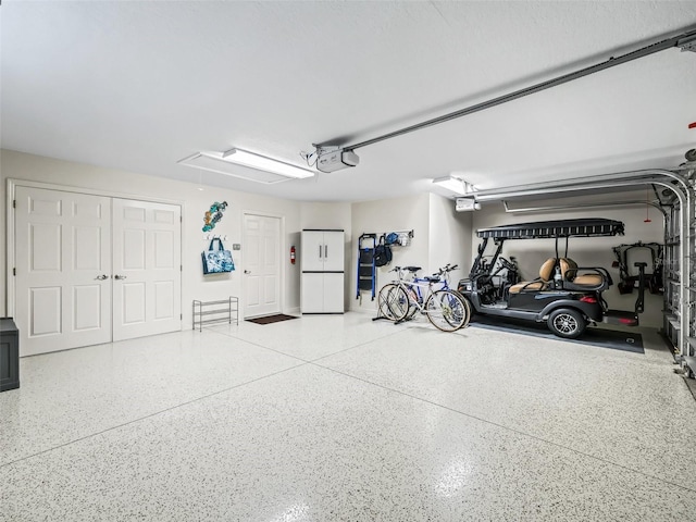 garage with a garage door opener and freestanding refrigerator