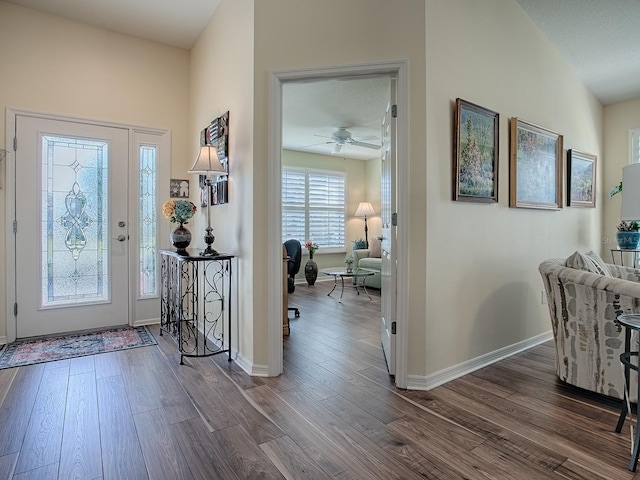 entrance foyer featuring a ceiling fan, dark wood-style flooring, and baseboards