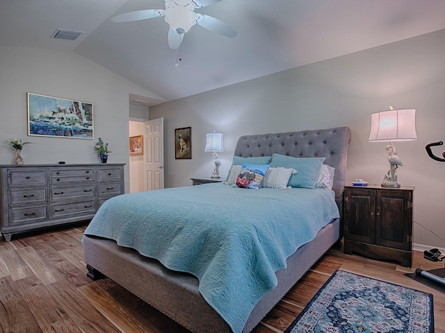 bedroom featuring lofted ceiling, visible vents, ceiling fan, wood finished floors, and baseboards