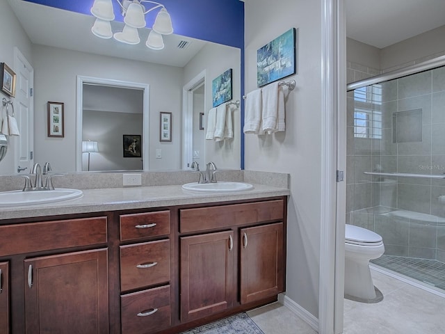 bathroom featuring tile patterned flooring, a sink, toilet, and a shower stall