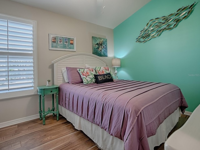 bedroom with wood finished floors and baseboards