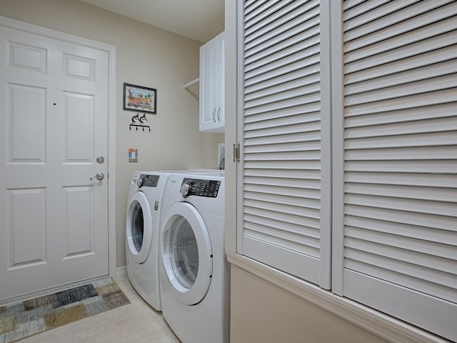 clothes washing area featuring cabinet space and washing machine and clothes dryer