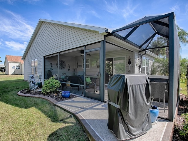 view of patio with glass enclosure, ceiling fan, and grilling area