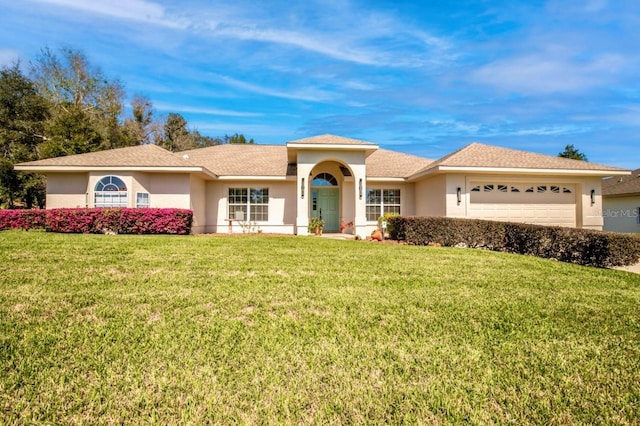 view of front of house featuring an attached garage, stucco siding, and a front yard