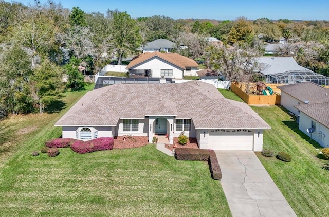 single story home featuring an attached garage, fence, driveway, roof with shingles, and a front yard