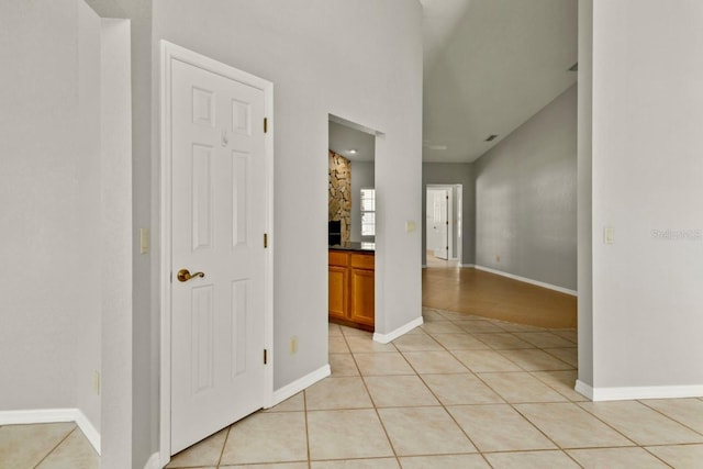 hall featuring light tile patterned floors and baseboards