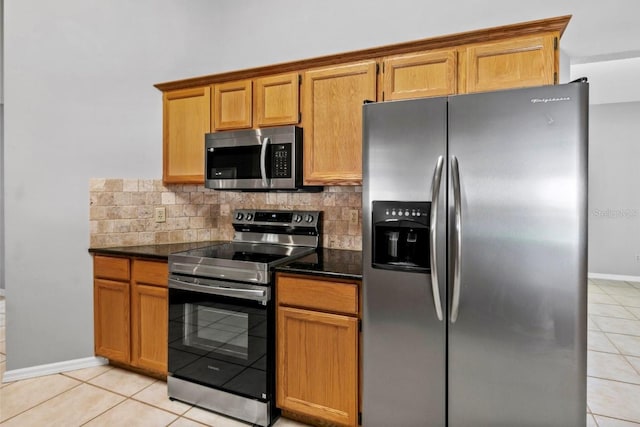 kitchen with light tile patterned floors, appliances with stainless steel finishes, and tasteful backsplash