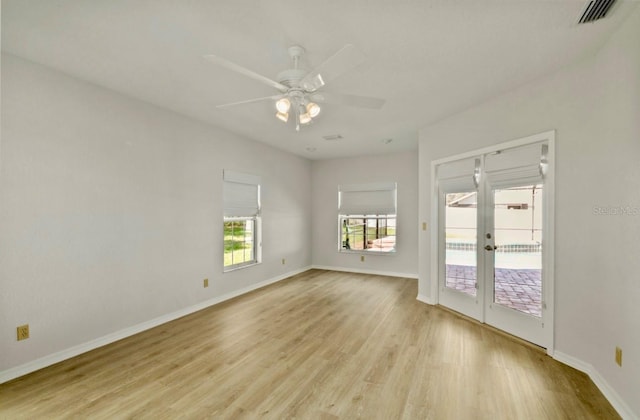 empty room with baseboards, ceiling fan, visible vents, and light wood-style floors