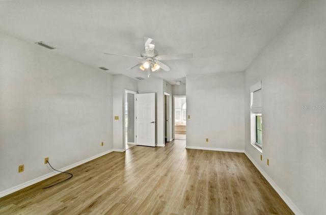 unfurnished bedroom featuring ensuite bath, wood finished floors, visible vents, and baseboards