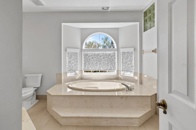 bathroom featuring tile patterned floors, toilet, and a bath