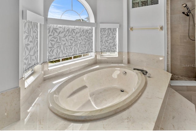 full bathroom with a bath and tiled shower