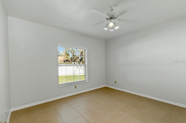 unfurnished room featuring ceiling fan, baseboards, and light tile patterned flooring