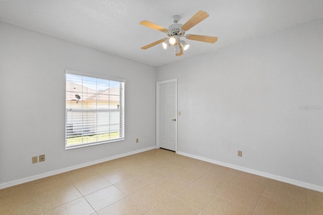 spare room with baseboards and a ceiling fan