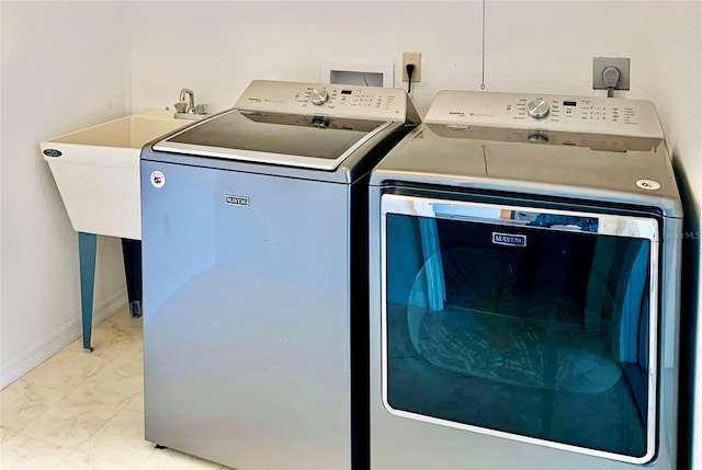 clothes washing area with laundry area, independent washer and dryer, and baseboards