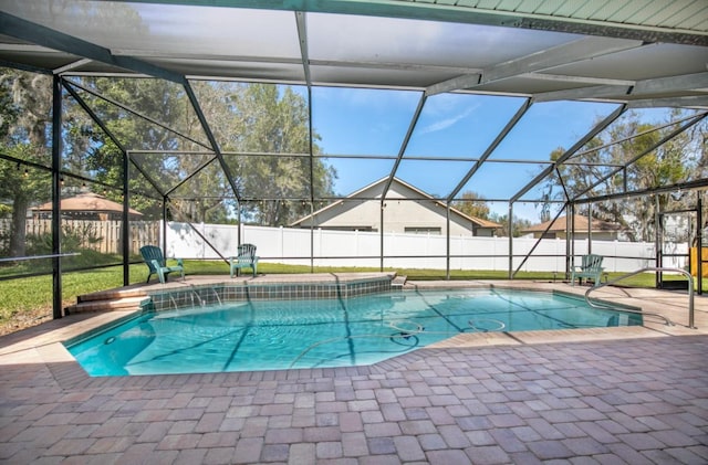 view of swimming pool with glass enclosure, a patio area, and a fenced backyard