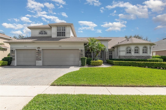 view of front of property featuring stone siding, a front lawn, decorative driveway, and stucco siding