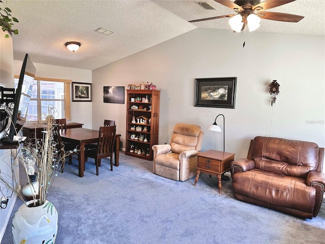 carpeted office featuring lofted ceiling, ceiling fan, visible vents, and a textured ceiling