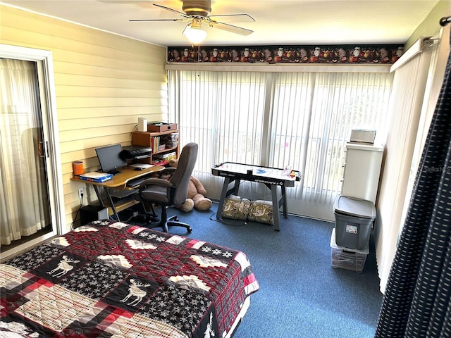 bedroom with ceiling fan, wood walls, and carpet