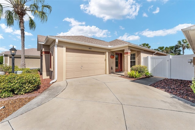 ranch-style home featuring stucco siding, an attached garage, a gate, fence, and driveway