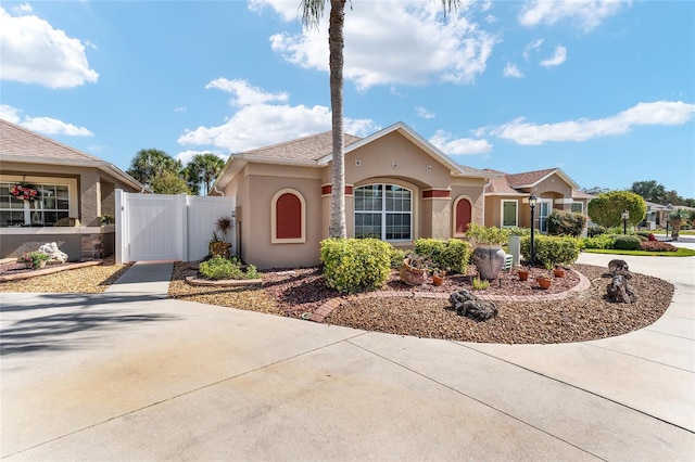 view of front of property featuring driveway, a gate, and stucco siding