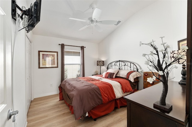 bedroom featuring a ceiling fan, visible vents, vaulted ceiling, baseboards, and light wood finished floors