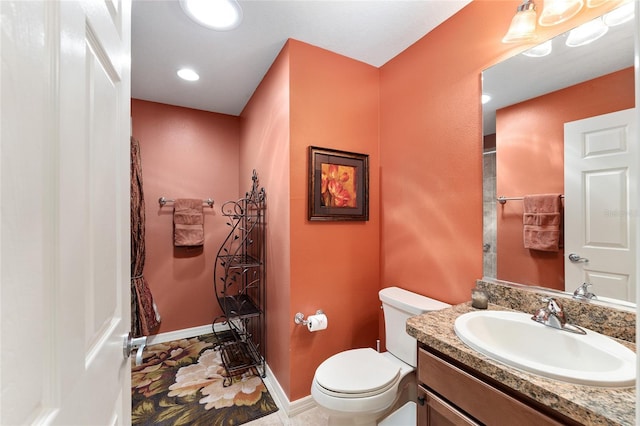 bathroom with toilet, recessed lighting, baseboards, and vanity