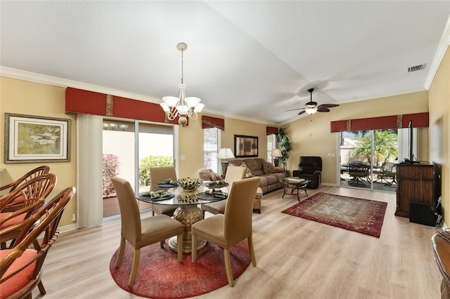 dining area featuring lofted ceiling, ornamental molding, visible vents, and light wood-style floors