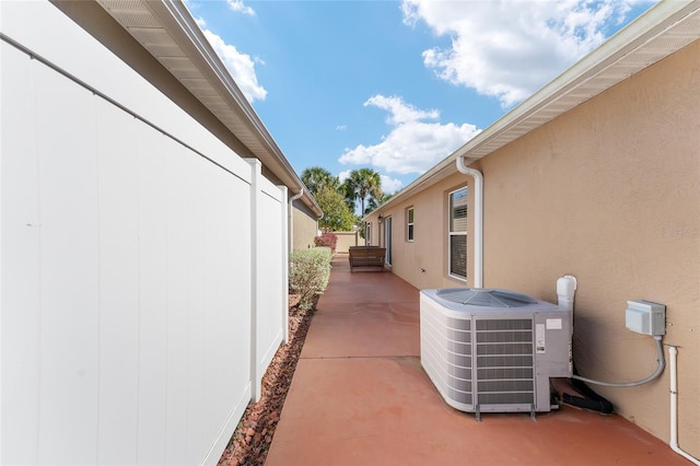 view of property exterior featuring a patio, cooling unit, and stucco siding