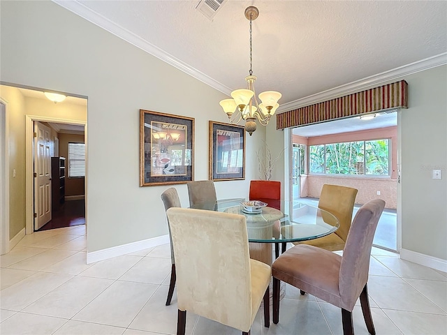 dining area with ornamental molding, an inviting chandelier, and light tile patterned floors