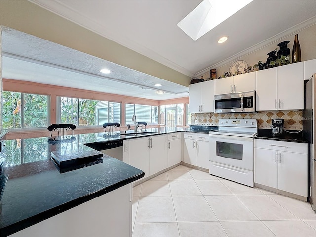 kitchen featuring stainless steel appliances, decorative backsplash, a sink, and crown molding