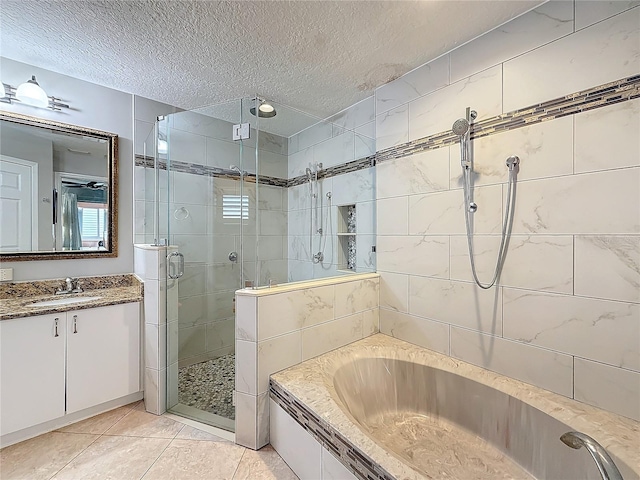 bathroom with a garden tub, a shower stall, a textured ceiling, vanity, and tile patterned floors