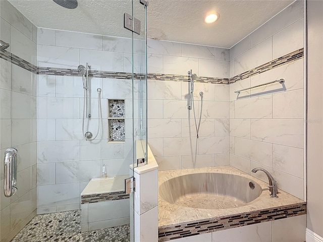 bathroom with a bathtub, tiled shower, and a textured ceiling