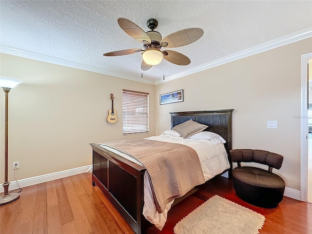 bedroom with baseboards, crown molding, a textured ceiling, and light wood finished floors