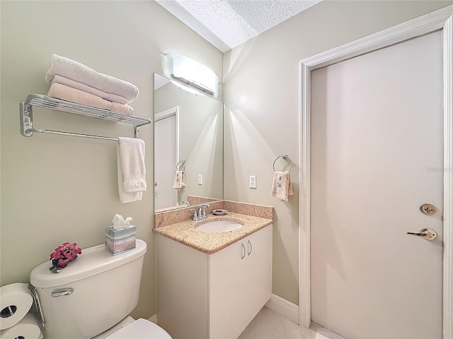 bathroom with a textured ceiling, lofted ceiling, toilet, vanity, and baseboards