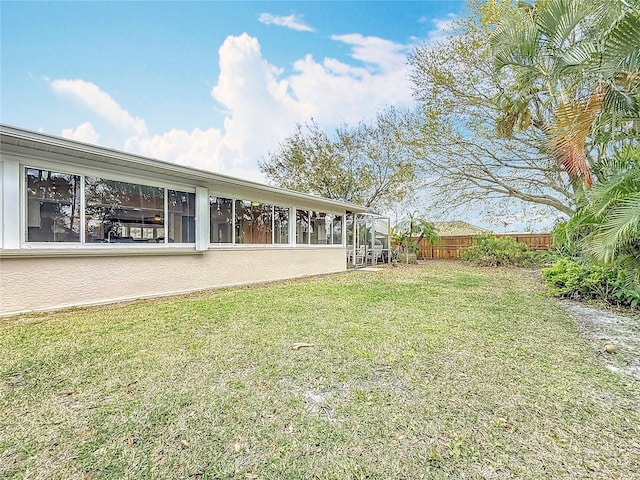 view of yard featuring a sunroom and fence